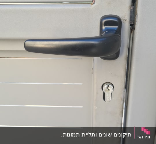 ידית דלת ומנעול על דלת מתכת אפורה